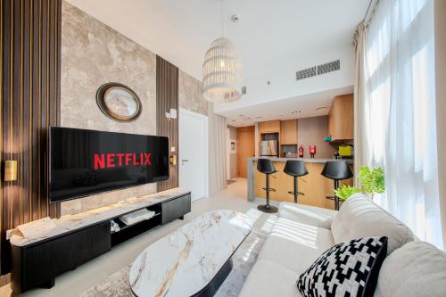 a living room with a couch and a tv at 1BR The Golden Souq by Blue Cloud Holidays in Sharjah Intl