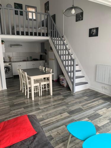 une cuisine et une salle à manger avec une table et un escalier dans l'établissement L appart d Ange 1 idéalement situe 37m2 entre port et village, à Gruissan