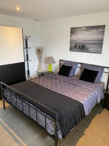 - une chambre dotée d'un grand lit avec des draps violets et un tableau dans l'établissement Charmant appartement 3 étoiles entièrement rénové 