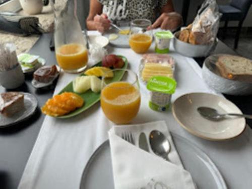 a table topped with plates of food and orange juice at 5ª Vigia in Porto de Mós