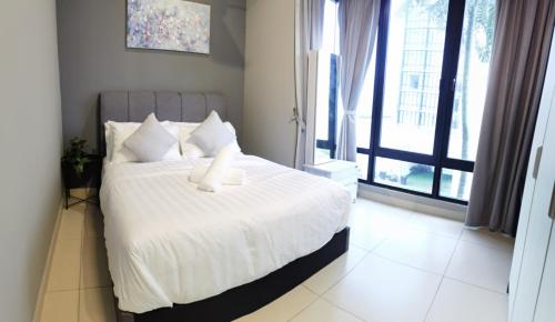a bedroom with a large bed with white sheets and pillows at SUPERB Klean & Cozy Midhill in Genting Highlands