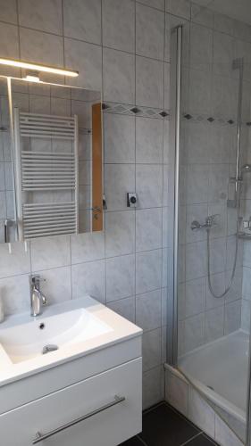 a bathroom with a sink and a shower and a tub at Ferienwohnung in Bad Oeynhausen in Bad Oeynhausen