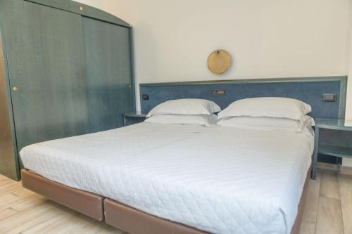 a large white bed with a blue headboard in a room at Toscana Ambassador in Poggibonsi