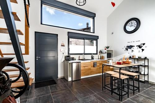 une cuisine avec une grande fenêtre et une porte noire dans l'établissement Love Room Loft Spa logement entier balneo exterieur, à Ambronay