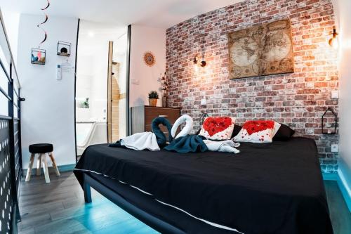 2 personnes assises sur un lit dans une pièce dans l'établissement Love Room Loft Spa logement entier balneo exterieur, à Ambronay