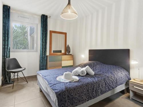 - une chambre avec un lit doté de serviettes et de chapeaux dans l'établissement Appt 2 chambres, 3 étoiles, piscine, wifi, parking, clim, à Saint-Raphaël