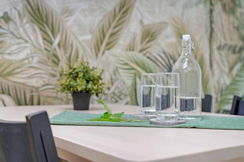 a bottle of water and a glass on a table at Bush and Bay Haven in Bonnet Bay