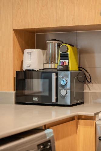 a microwave sitting on top of a kitchen counter at 1BR The Mocha house by Blue Cloud Holidays in Sharjah Intl