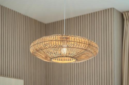a wicker chandelier hanging from a ceiling at 1BR The Mocha house by Blue Cloud Holidays in Sharjah Intl