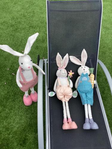 three stuffed rabbits in a box on the grass at Relax Apartman in Sümeg