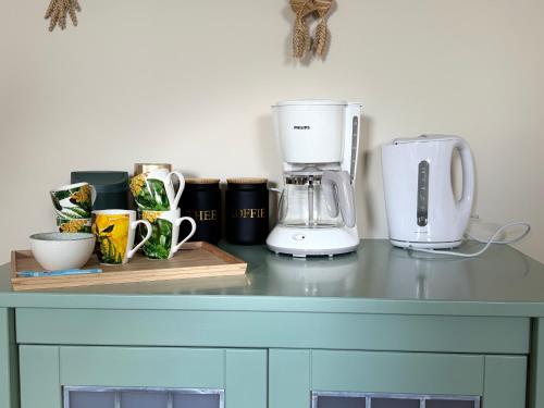 a counter with a coffee maker and cups on it at KorenGastvrij in Noordbroek