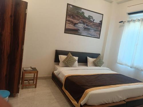 a bed in a bedroom with a picture on the wall at Hotel Annapurna Regency in Mirzāpur