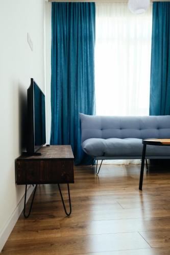 a living room with a couch and a television on a table at Luxury Suites White Sails in Batumi