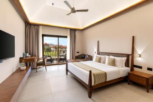 a bedroom with a large bed and a balcony at Sajjan Bagh Resort Kumbhalgarh in Kumbhalgarh