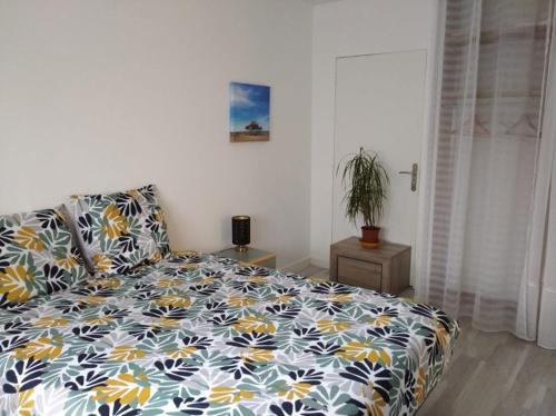 格拉迪尼昂Appartement et studio indépendants的一间卧室配有一张蓝色和黄色的床罩