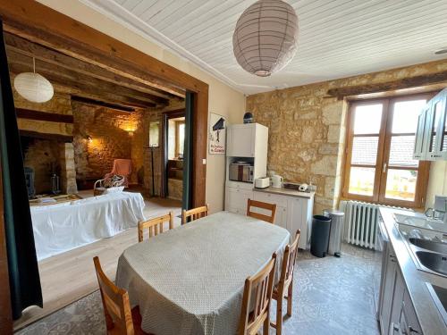 une cuisine et une salle à manger avec une table et des chaises dans l'établissement Les Althéas - Gîte familial avec terrasses - Sarlat, à Groléjac