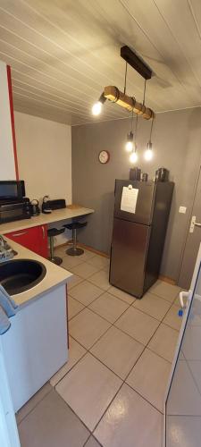 a kitchen with a refrigerator and a table at Location ST LEU CHEZ CARO in Étang