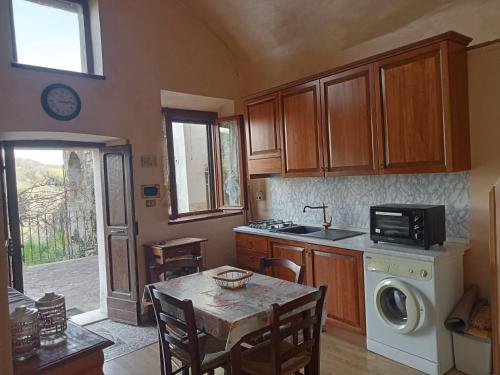a kitchen with a table and a sink and a microwave at La loggia del pappagallo in Gallese