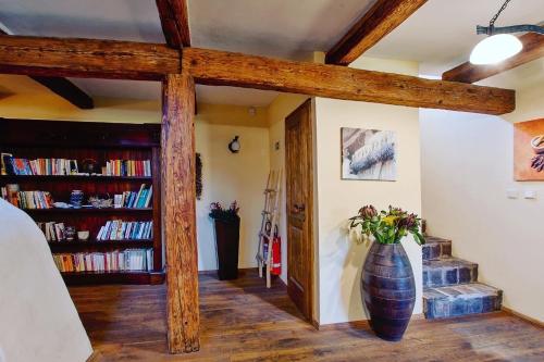 a room with a vase on the wall with books at Dvůr Olšiny -Hotel and Horse-riding in Karviná