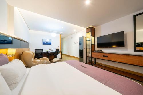 a hotel room with a large bed and a flat screen tv at Mini Hotel in Jincheon