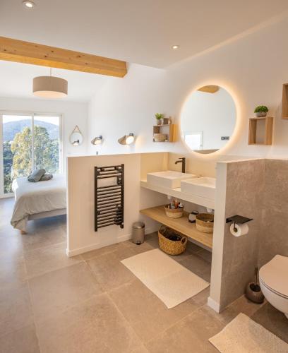 une salle de bain avec un lavabo, un miroir et un lit dans l'établissement Magnifique Villa piscine chauffée, climatisée, vue mer sur les Issambres, aux Issambres