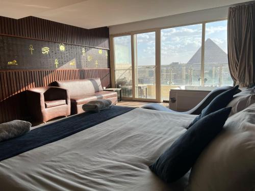 a bedroom with a large bed with a chair and a couch at New Comfort Inn Giza in Cairo