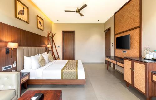 a hotel room with a bed and a tv at Sajjan Bagh Resort Kumbhalgarh in Kumbhalgarh
