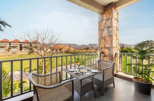 a patio with a table and chairs on a balcony at Sajjan Bagh Resort Kumbhalgarh in Kumbhalgarh