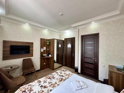 a hotel room with a bed and a chair at Hotel Park in Batumi