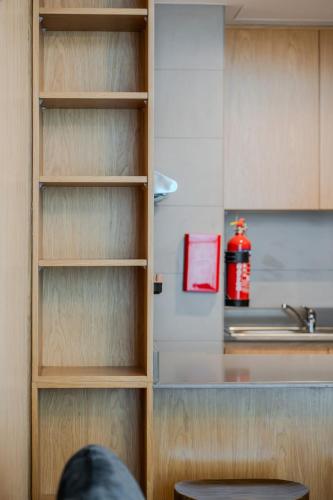 a kitchen with wooden shelves and a sink at 1BR Exclusive Apartment - Charisma in Sharjah Intl