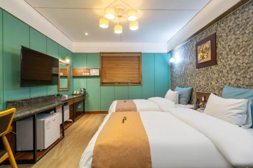 a hotel room with two beds and a television at Mini Hotel in Jincheon