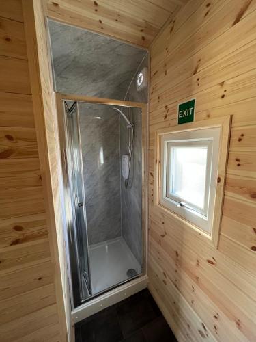 a shower in a wooden room with a window at Heb Pods - North Pod in Uig