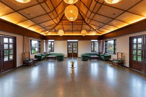 a large room with couches and tables and windows at Sajjan Bagh Resort Kumbhalgarh in Kumbhalgarh