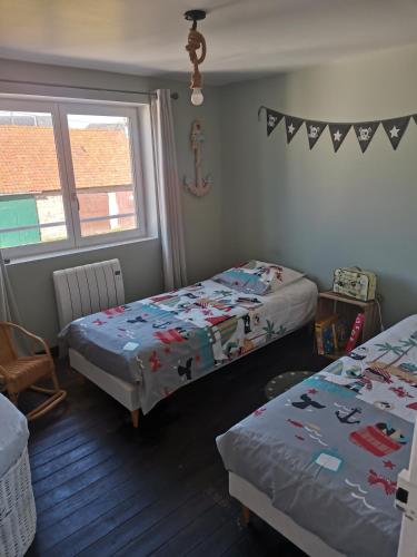 une chambre avec deux lits et une fenêtre dans l'établissement Ancienne maison marin pêcheur, à Cayeux-sur-Mer