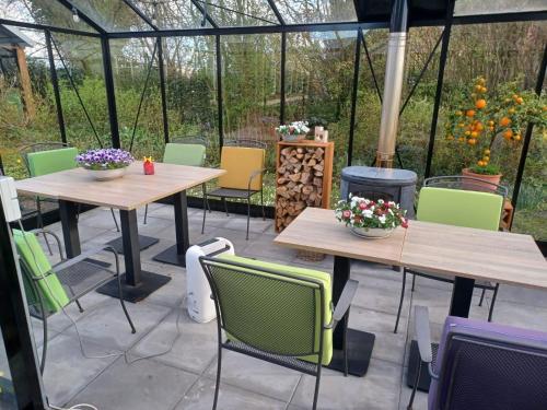 a patio with tables and chairs and a wood stove at KorenGastvrij in Noordbroek