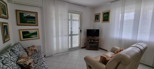 a living room with a couch and a tv at Casa vacanze di Elisa in Caniparola di Fosdinovo