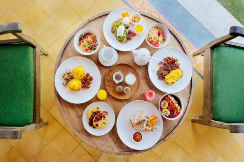 una tavola rotonda con piatti di cibo sopra di Aradhana Villas by Ekosistem a Canggu