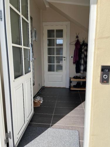 a hallway with a white door and a tiled floor at Cosy Guesthouse near Copenhagen in Rødovre