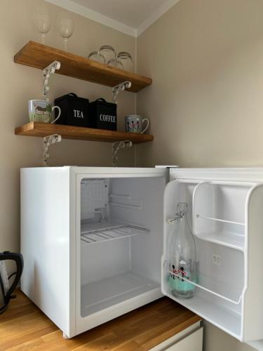 a white refrigerator with its door open in a kitchen at Cosy Guesthouse near Copenhagen in Rødovre