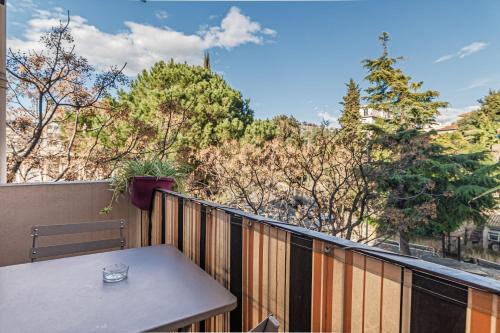 - une table sur un balcon avec vue sur les arbres dans l'établissement Beautiful 3 room apartment - Parking -Centre -Tram, à Nice