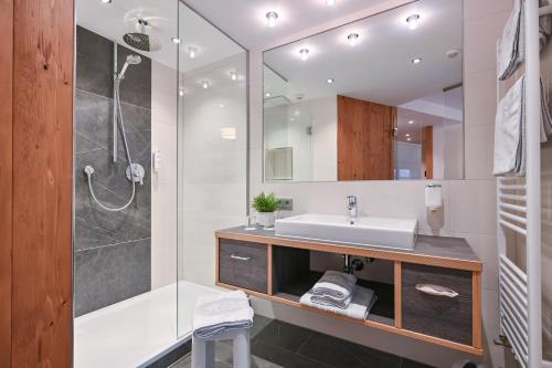 a bathroom with a sink and a shower at Hotel Helmer in Schwangau