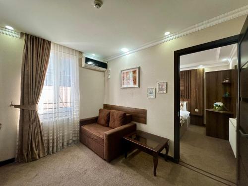 a living room with a couch and a mirror at Hotel Park in Batumi
