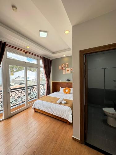a bedroom with a bed and a balcony at Quang Minh Dalat Hotel in Da Lat