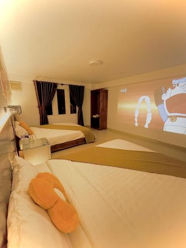 a hotel room with two beds with a teddy bear on them at Quang Minh Dalat Hotel in Da Lat