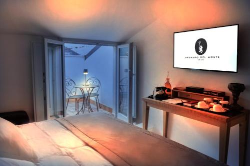 a bedroom with a bed and a television on a wall at Hotel Casa Bianconi in Norcia