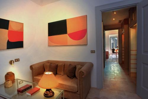a living room with a couch and paintings on the wall at Hotel Casa Bianconi in Norcia