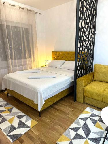 Un dormitorio con una cama y una silla amarilla. en Apartman Most, en Bosanska Gradiška