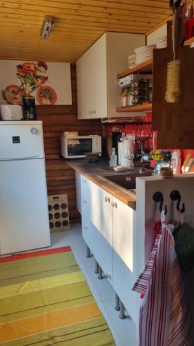 a kitchen with white cabinets and a colorful floor at Villa Roza in Murarátka