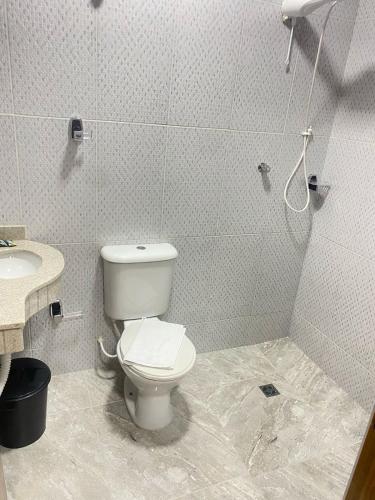 a bathroom with a toilet and a sink at Pousada Sagrada Devoção in Aparecida