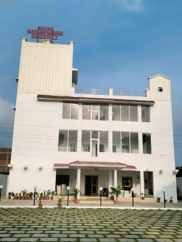 a white building with a clock tower on top at Hotel Annapurna Regency in Mirzāpur